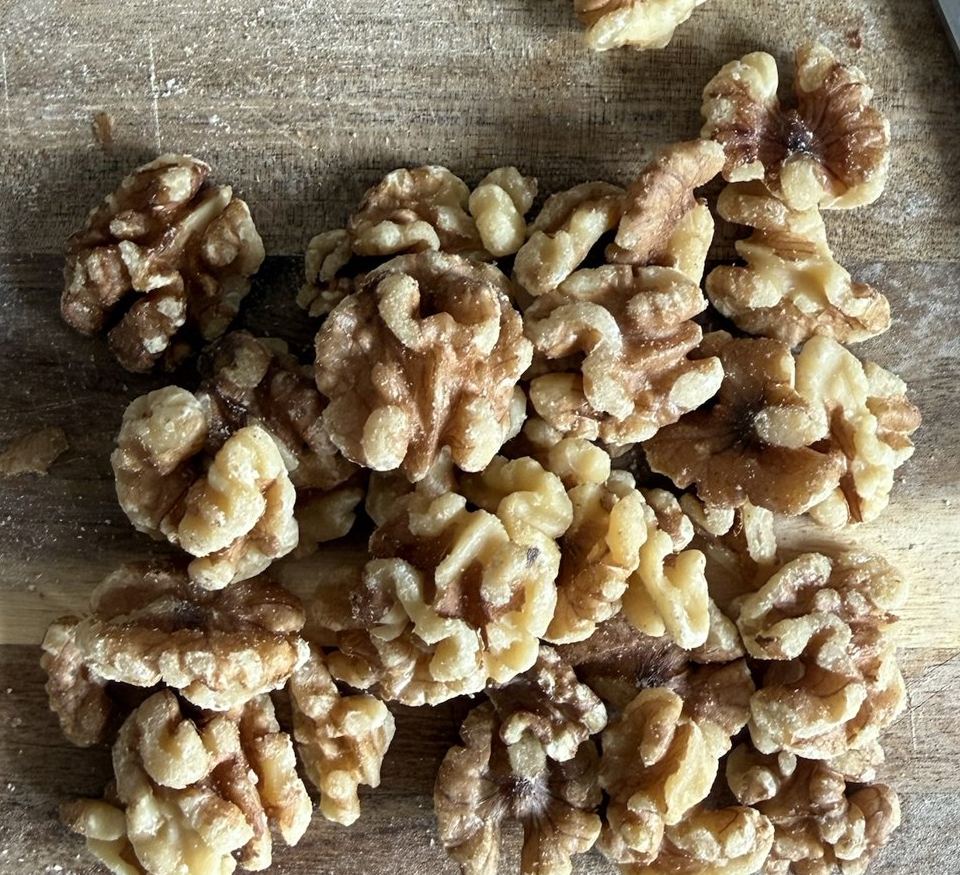 Pile of walnut halves on a wooden cutting board