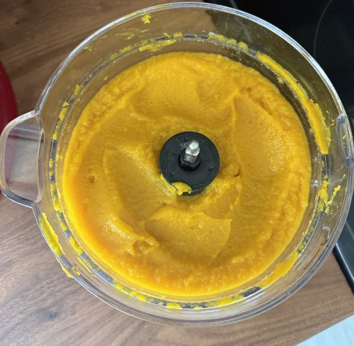 Smooth orange pumpkin puree in a food processor bowl