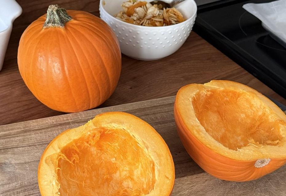 Small pie pumpkins cut in half and scooped out on a cutting board